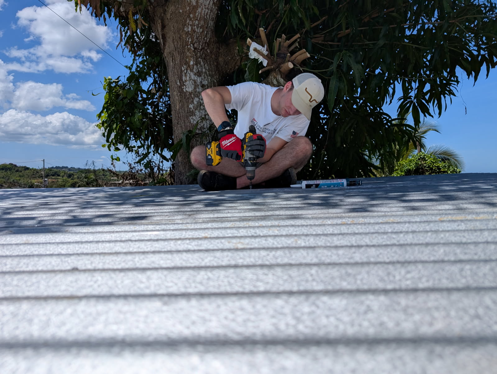 Elijah Dekker worked hard to get the metal flashing up onto the roof of the chicken coop.